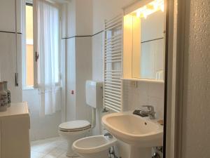 een witte badkamer met een toilet en een wastafel bij Marie Claire in Levanto