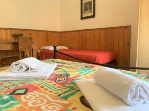 een slaapkamer met 2 bedden en handdoeken bij Marie Claire in Levanto