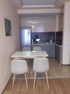 cocina con mesa, sillas y nevera en Batumi apartment in front of Sheraton en Batumi