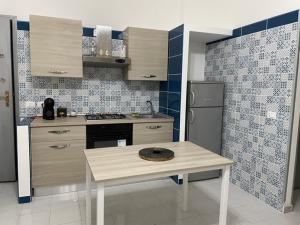a kitchen with a table and a refrigerator at Casa anticaglie P.Secca in Punta Secca