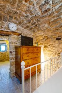 a bedroom with a dresser with a clock on the wall at Diamante Stone House in Sitia