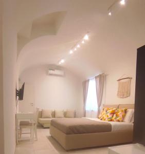 - une chambre avec un lit, un canapé et une fenêtre dans l'établissement L Antico Forno Bari Centro Storico, à Bari