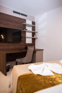 a bedroom with a desk and a bed with a chair at Hotel Meduza in Senj