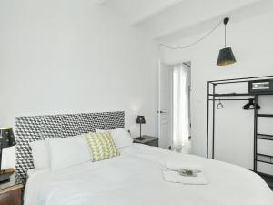 a bedroom with a white bed with a black and white headboard at Casa nanit apt a in Hospitalet de Llobregat