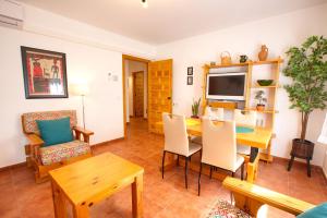 ein Wohnzimmer mit Tisch und Stühlen und einem Fernseher in der Unterkunft Cuencaloft La casa del tío Serafín in Cuenca