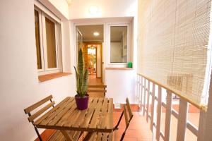 eine Veranda mit einem Holztisch und einer Topfpflanze in der Unterkunft Cuencaloft La casa del tío Serafín in Cuenca + 12 Fotos