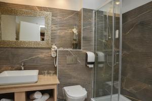 a bathroom with a toilet and a sink and a shower at Hotel Meduza in Senj