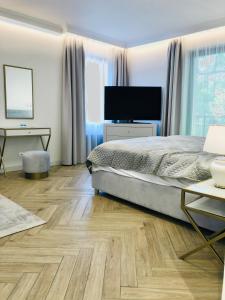 sypialnia z łóżkiem i telewizorem z płaskim ekranem w obiekcie Luxury Apartments in Residence Maritime w mieście Międzyzdroje +37 zdjęć