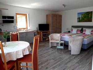 a bedroom with a bed and a table and a kitchen at Ferienappartement Lieser in Bernkastel-Kues