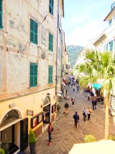 a group of people walking down a street next to buildings at Il Geranio in Finale Ligure