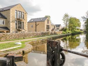 a swan walks along a canal in front of houses at 6 Lock View in Skipton
