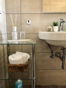 a bathroom with a sink and a glass table with towels at Villa Dora - Mediterranean family house for 9 with private garden, BBQ, sea view and private parking for 4 cars in Pag