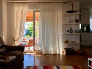 a living room with a couch and a sliding glass door at Villa Dora - Mediterranean family house for 9 with private garden, BBQ, sea view and private parking for 4 cars in Pag