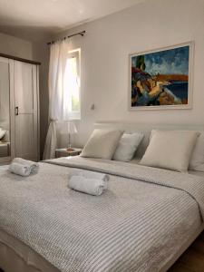 a white bedroom with two beds with towels on them at Villa Dora in Pag