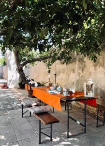 a table with an orange table cloth sitting under a tree at Villa Dora in Pag