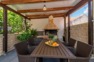a patio with a table and a fireplace at Apartments Orlic in Trogir