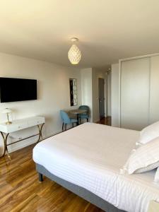 a bedroom with a bed and a desk and a tv at Maison de la Marine in Cagnes-sur-Mer