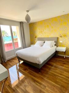 a bedroom with a large bed with yellow walls at Maison de la Marine in Cagnes-sur-Mer