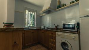 a kitchen with a washing machine and a microwave at Casa Coral - San José in San José