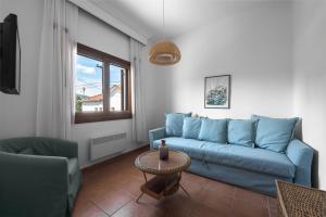 a living room with a blue couch and a table at Kalokerino house in Olympiada +1 photo