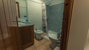 a bathroom with a toilet and a sink and a shower at Casa Coral - San José in San José