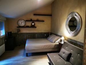a bedroom with a bed and a clock on the wall at Le Puits de la Foltière in Azay-sur-Cher
