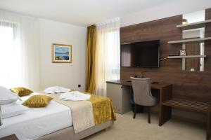 a hotel room with a bed and a desk and a television at Hotel Meduza in Senj