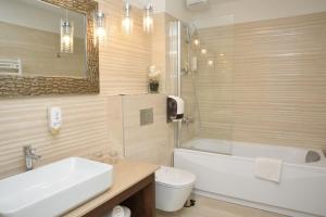 a bathroom with a sink and a tub and a toilet at Hotel Meduza in Senj