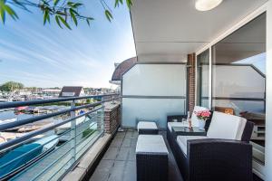 a balcony with chairs and a view of a harbor at Kaag Resort in Warmond