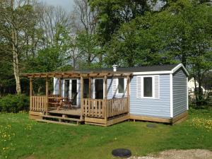 una casa pequeña con porche y terraza en Jelling Family Camping & Cottages en Jelling