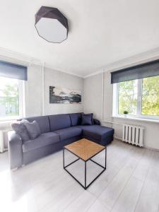 a living room with a blue couch and a table at Centrum Apartement in Valga