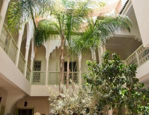 un edificio con palmeras en el patio en Dar Crystal, en Marrakech