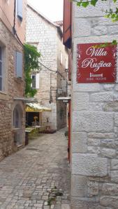 un callejón con una señal en el lateral de un edificio en Villa Ruzica, en Trogir