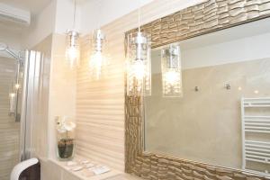a bathroom with two chandeliers and a mirror at Hotel Meduza in Senj