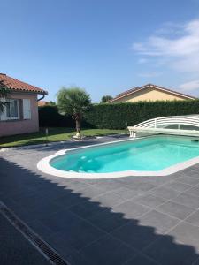 a swimming pool in a yard next to a house at Chambres d'Hôtes Chez Florence in Montmerle Sur Saône