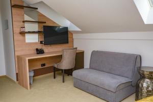 um quarto com uma secretária, uma cadeira e uma televisão em Hotel Meduza em Senj