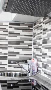 a sink in a bathroom with black and white tiles at Centrum Apartement in Valga