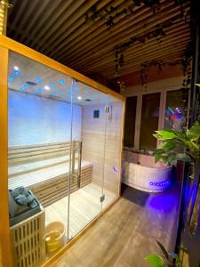a bathroom with a shower and a bath tub at Capsule Wellness - sauna - balneo - machine de sport privatif - PS5 - 2 chambres in Valenciennes