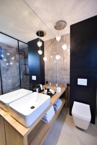 La salle de bains est pourvue d'un lavabo blanc et de toilettes. dans l'établissement Koncept domki, à Jantar