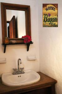 a bathroom with a sink with a mirror and a mirror at Hotel Bugamvillas Tapalpa in Tapalpa