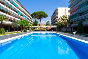 a large blue swimming pool next to a building at Apartment Llavaneres II in Sant Andreu de Llavaneres