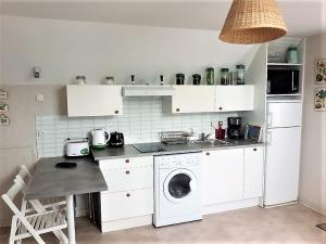 eine Küche mit einer Waschmaschine und einem Geschirrspüler in der Unterkunft LA BIGOTTIERE DU PORT in Saint-Georges-sur-Cher