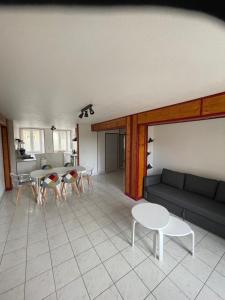 a living room with a couch and a table and chairs at Le petit écrin champenois in Étoges