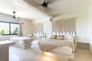 1 dormitorio blanco con 2 camas y ventana en Tulum Townhouse by Amansala, en Tulum