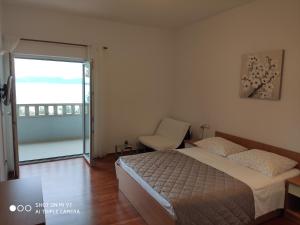 een slaapkamer met een bed, een stoel en een raam bij Apartment Valentina in Brela