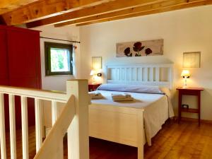 ein Schlafzimmer mit einem weißen Bett und einer Treppe in der Unterkunft Cuore Della Valle in Cefalú