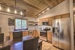 a kitchen with a stainless steel refrigerator and wooden cabinets at Modern Mountain Chalet Near Donner Lake! in Truckee