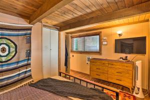 a bedroom with a bed and a tv and a dresser at Running Springs A-Frame with Deck and Mtn Views! in Running Springs
