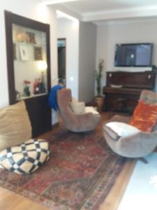 - un salon avec deux chaises et un canapé dans l'établissement Traditional Villa In S Pedro , ESTORIL, à Alapraia