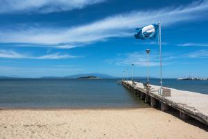 a beach with a flag on a pier at Kalokerino house in Olympiada